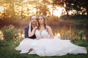 A romantic sunset wedding portrait set against golden light and natural foliage.