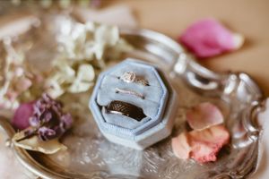 Delicate jewelry and wedding accessories artfully arranged on a vintage-style surface.
