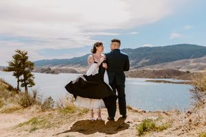 Couple shares intimate moment overlooking mountain lake vista.