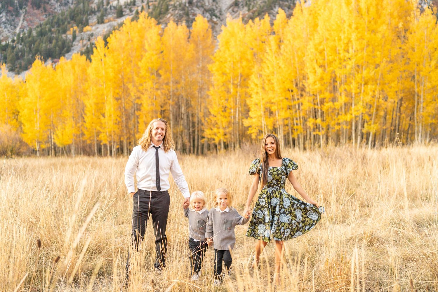 A family stands together in a golden aspen grove during autumn at White Pine Campground.