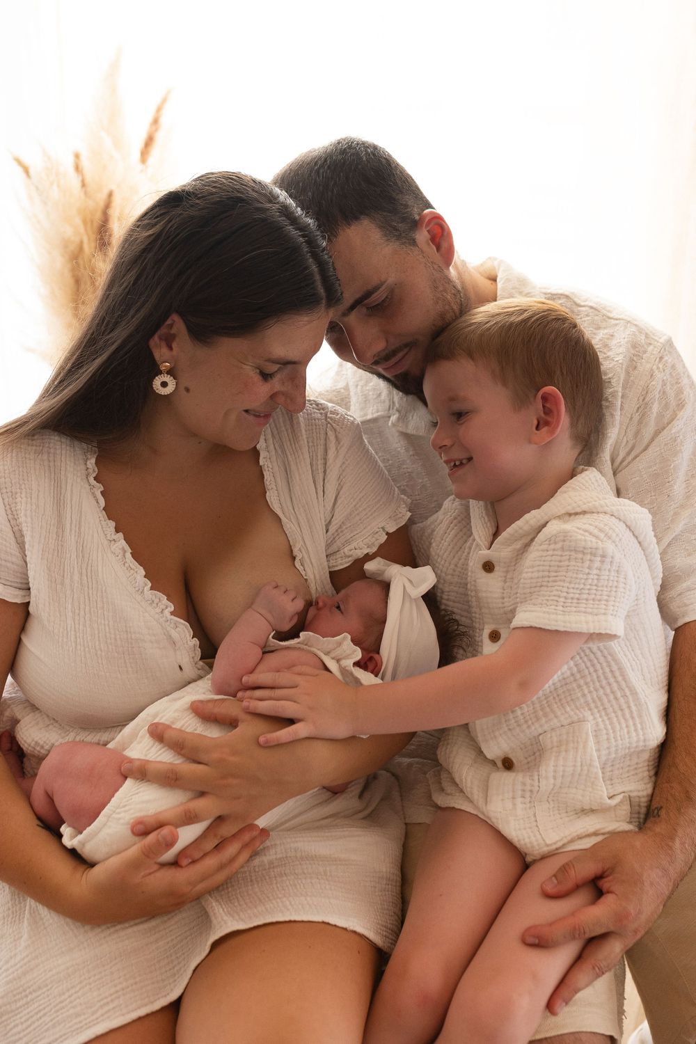 Portrait de famille incluant l'allaitement du nouveau-né et la présence de l'aîné, séance photo famille et vie en studio à Niort.