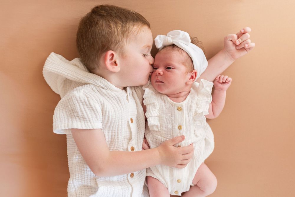 Câlin tendre entre un bébé et son grand frère/sœur en studio, capturer la complicité de la fratrie chez votre photographe à Niort.