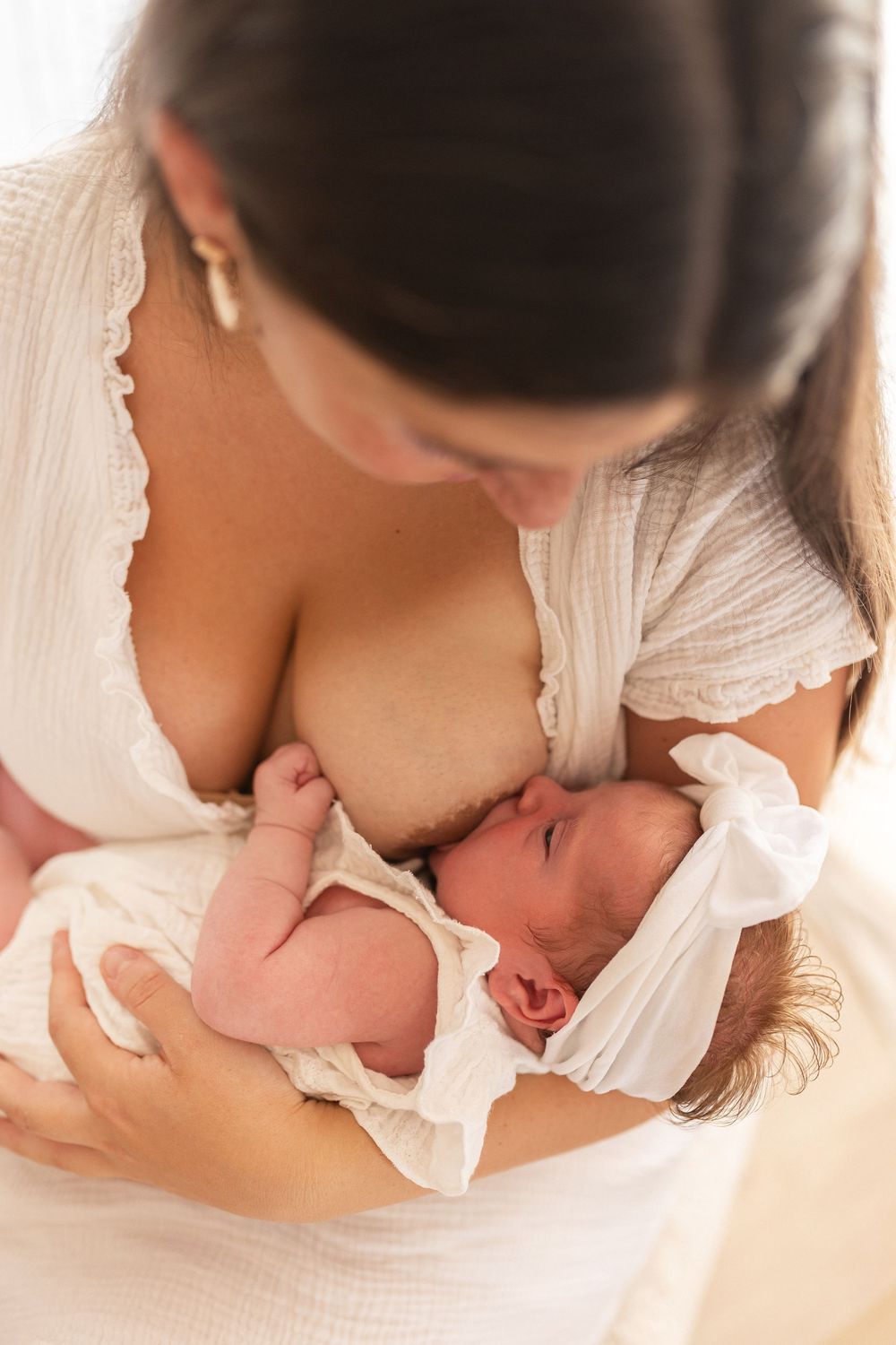 Moment sacré d'un allaitement entre maman et bébé en studio, photographie de maternité intime et douce à Niort (79).