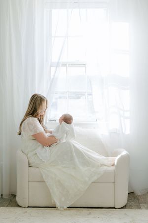 Mom holding baby near window in the Essex Studio.