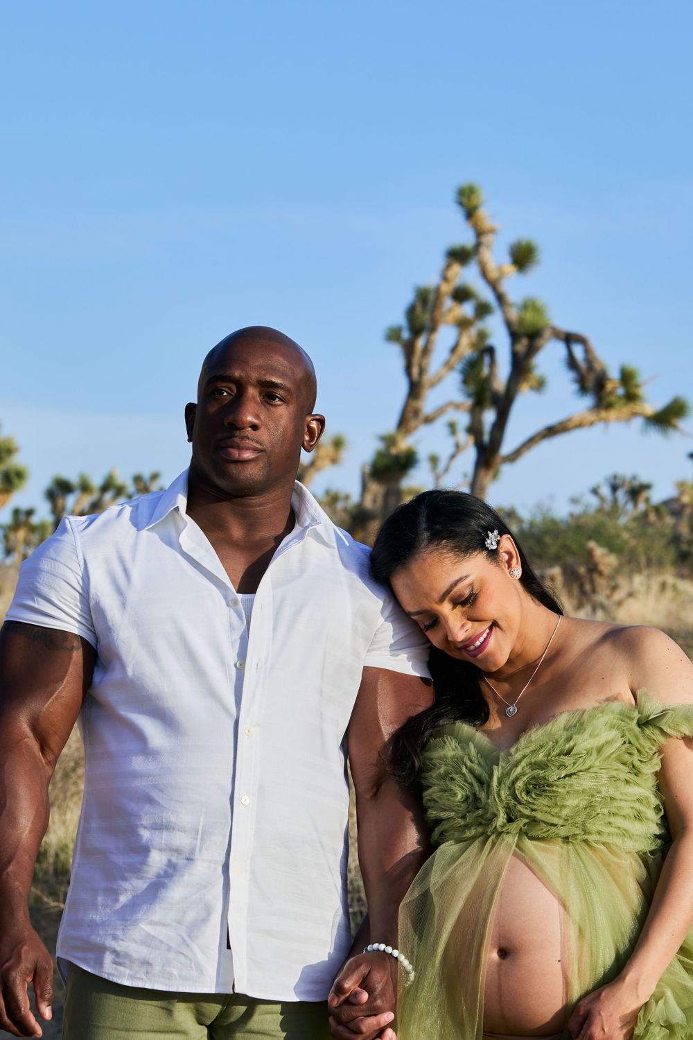 Maternity photo of an expectant couple in a desert landscape with Joshua trees.