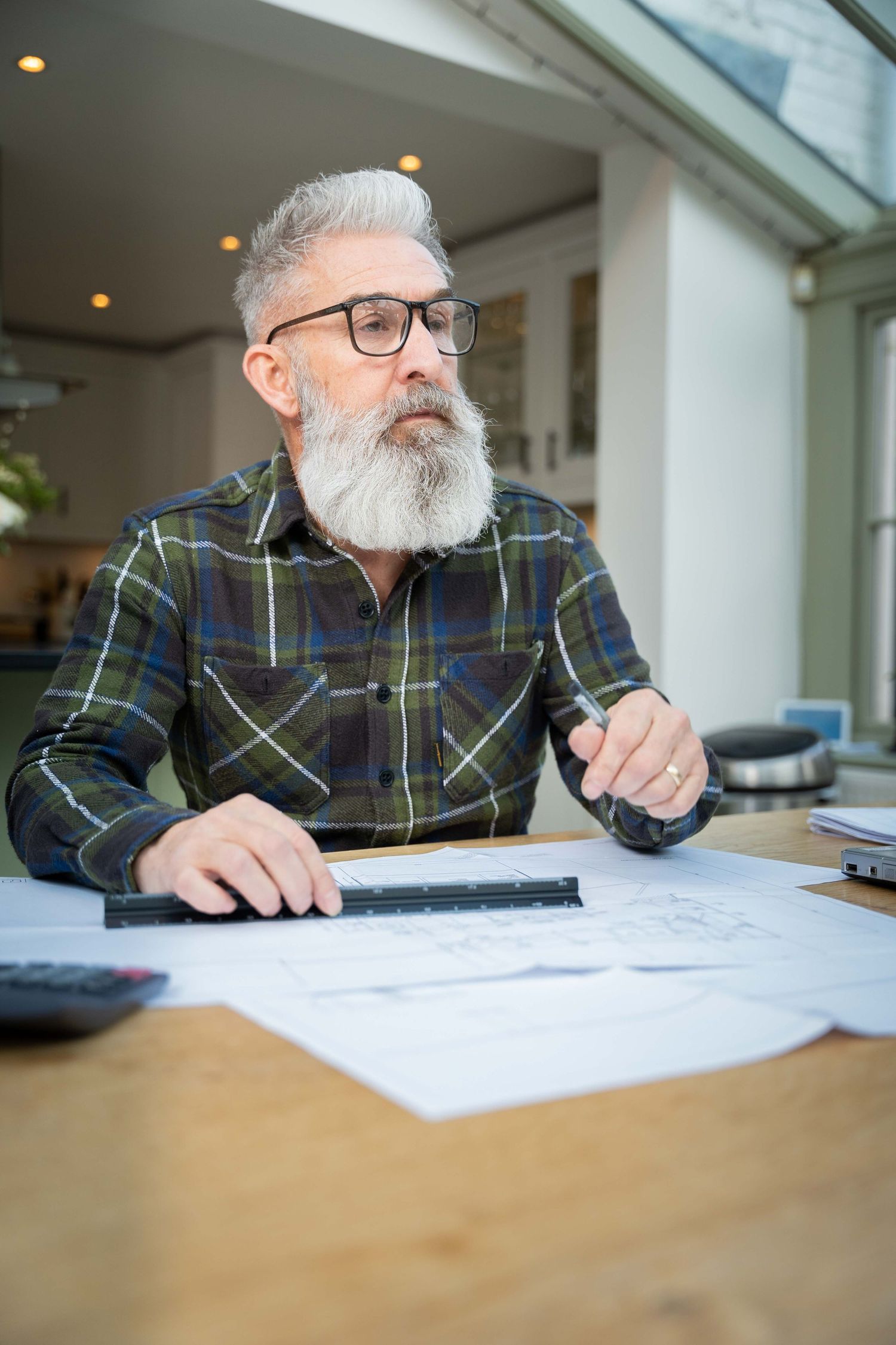 Personal branding photo of a guy sat at a table with is work laid out in front of him