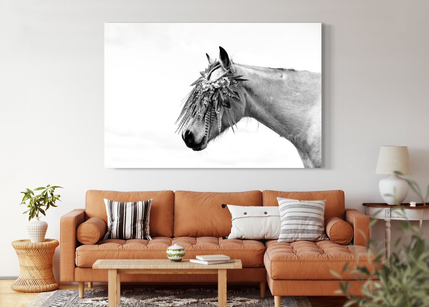 Black and white horse portrait hanging above modern tan leather sectional sofa.