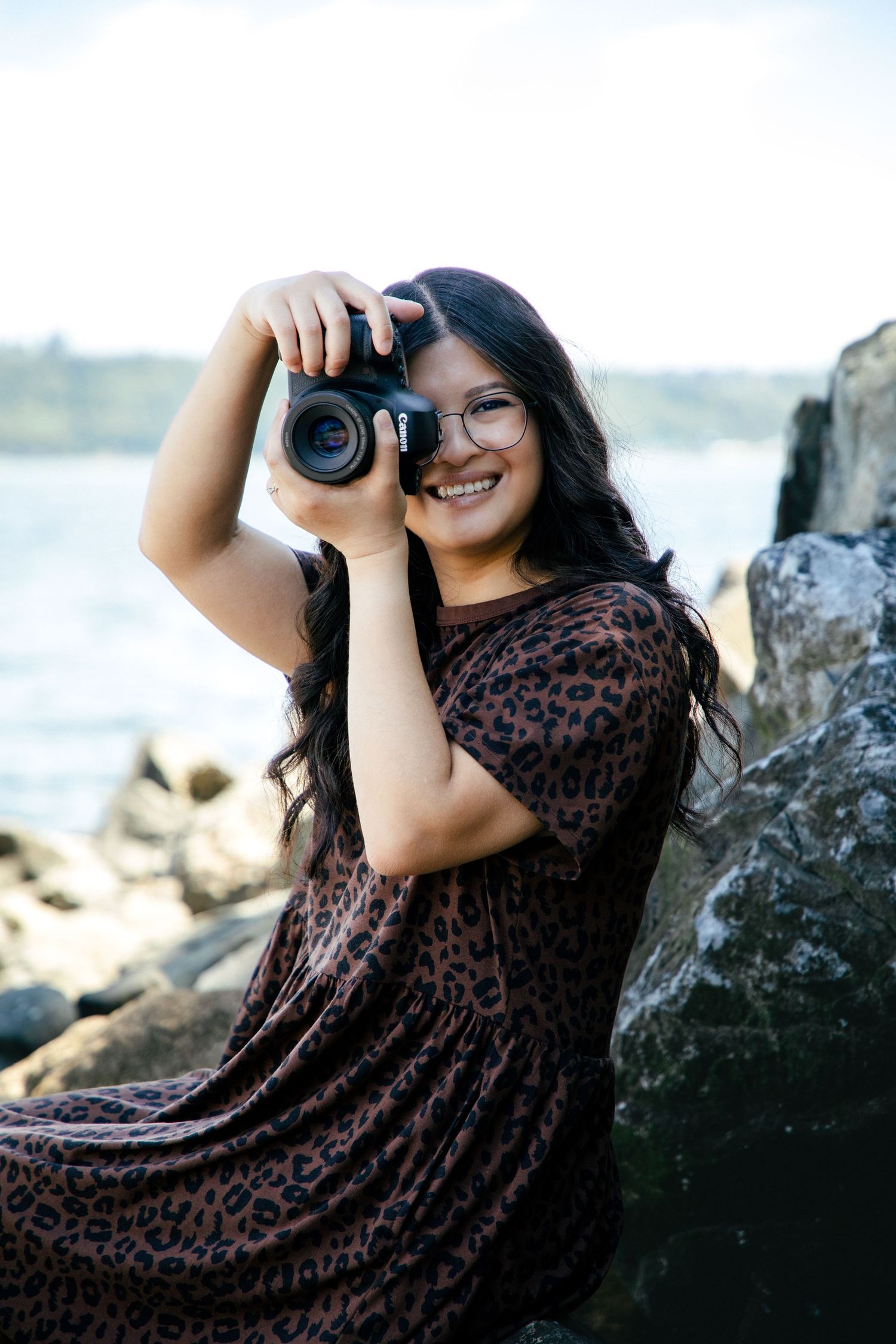 girl holding camera with a stripped dress on
