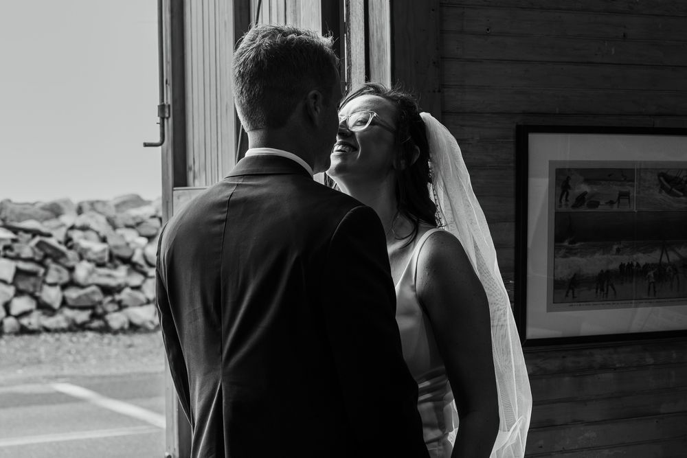 Black and white candid moment between two people during a wedding celebration.
