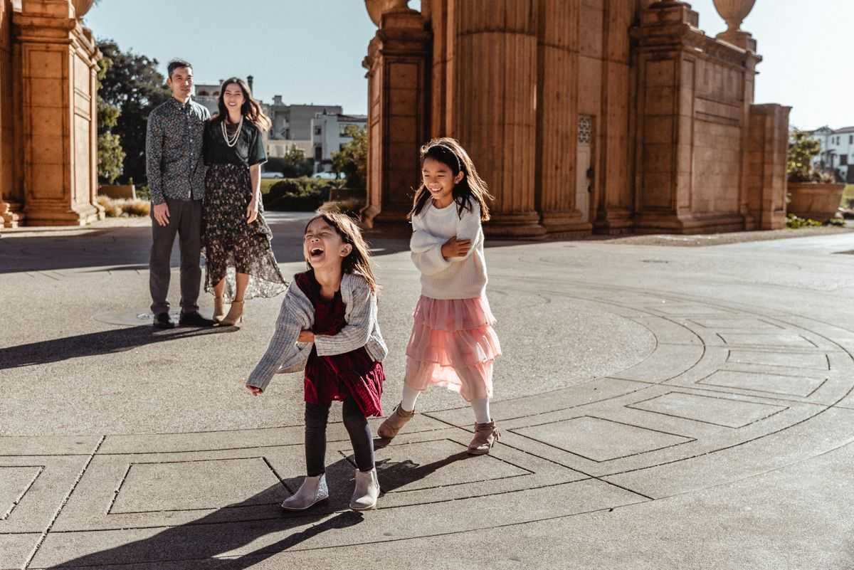 Beautiful family of two girls with parents having a fun time at Palace of Fine Arts, San Francisco.