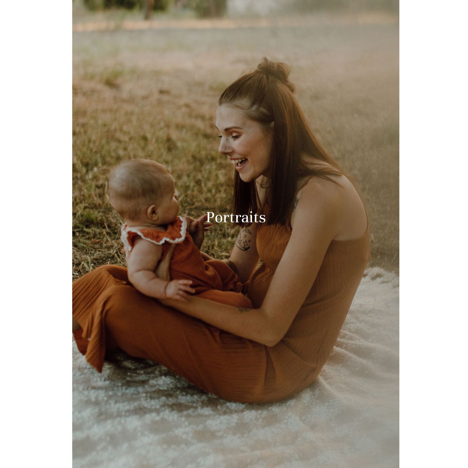 Parent and baby sharing a tender moment together while seated outdoors in warm earth-toned clothing at sunset.