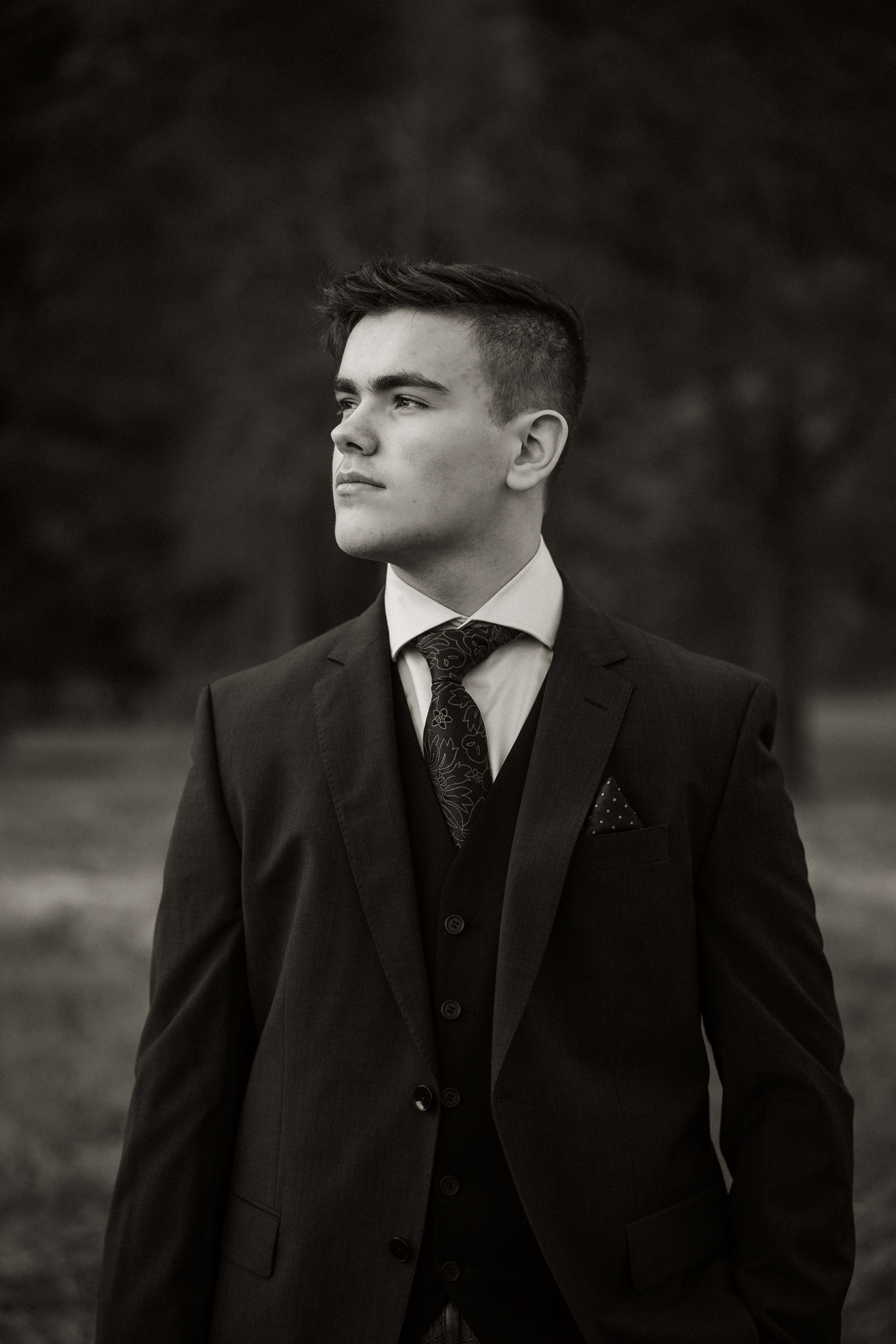 Black and white portrait showcasing a classic three-piece suit with patterned tie.