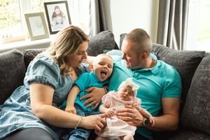 Happy family moment captured on couch with natural window light.