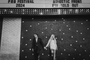 Black and white photo of an elopement couple standing together outside a brick venue in downtown Las Vegas.