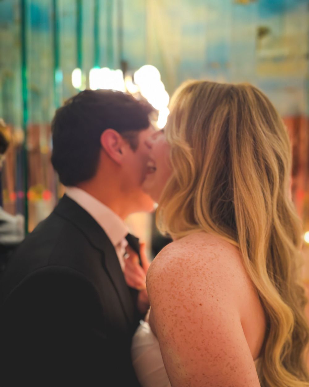A romantic wedding moment showing the couple's first dance in a traditional ballroom setting.