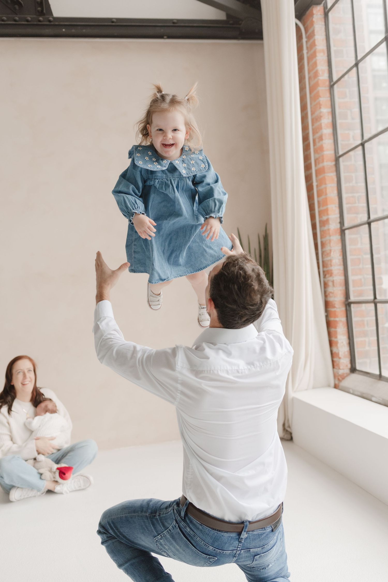 Dad lifting daughter at a Toronto Family Portrait session in Mint room studio, captured by Jess GC Photography