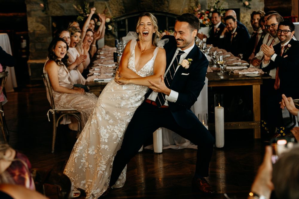 Couples dancing and celebrating at an indoor wedding reception.