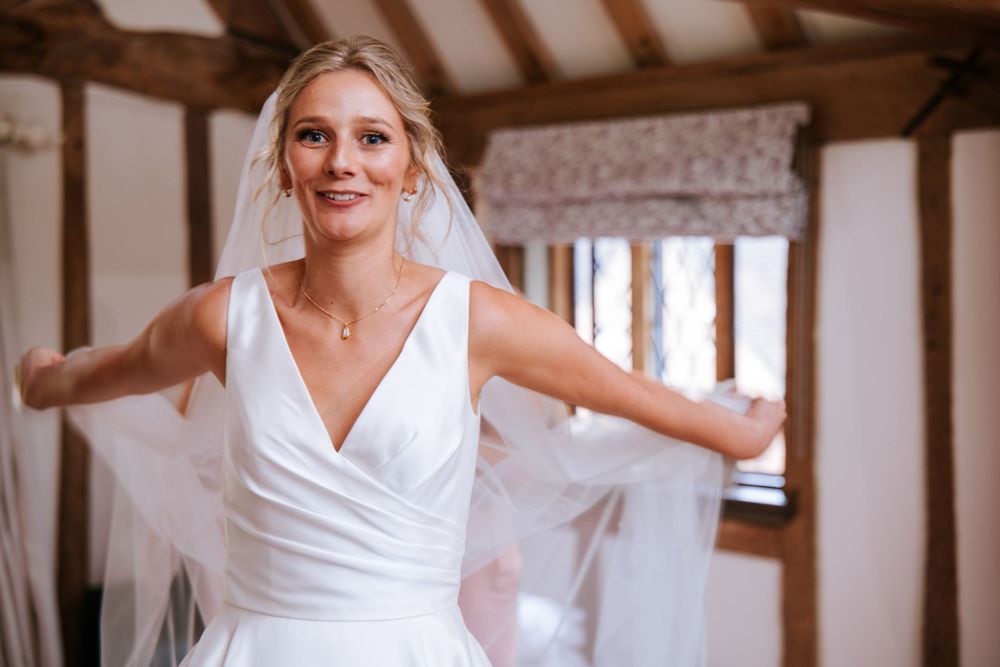 Bride adjusting her veil during morning preparations in Cain Manor Hampshire, captured by wedding photographer, Sylvia.