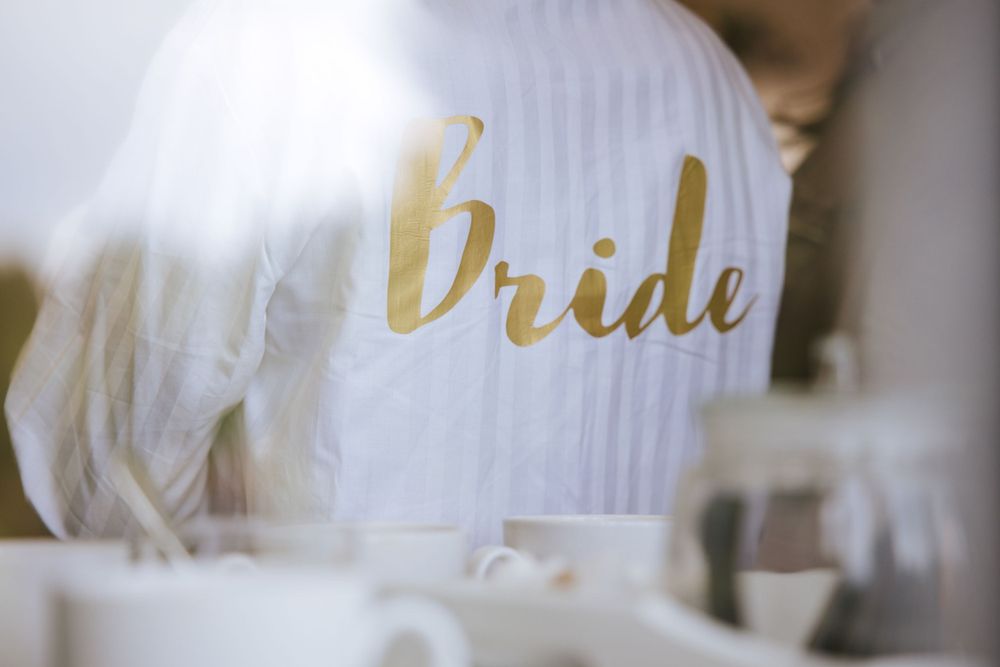 Back of bride's robe with Bride written on it, sneak peek from the outside of Cain Manor preparation room.