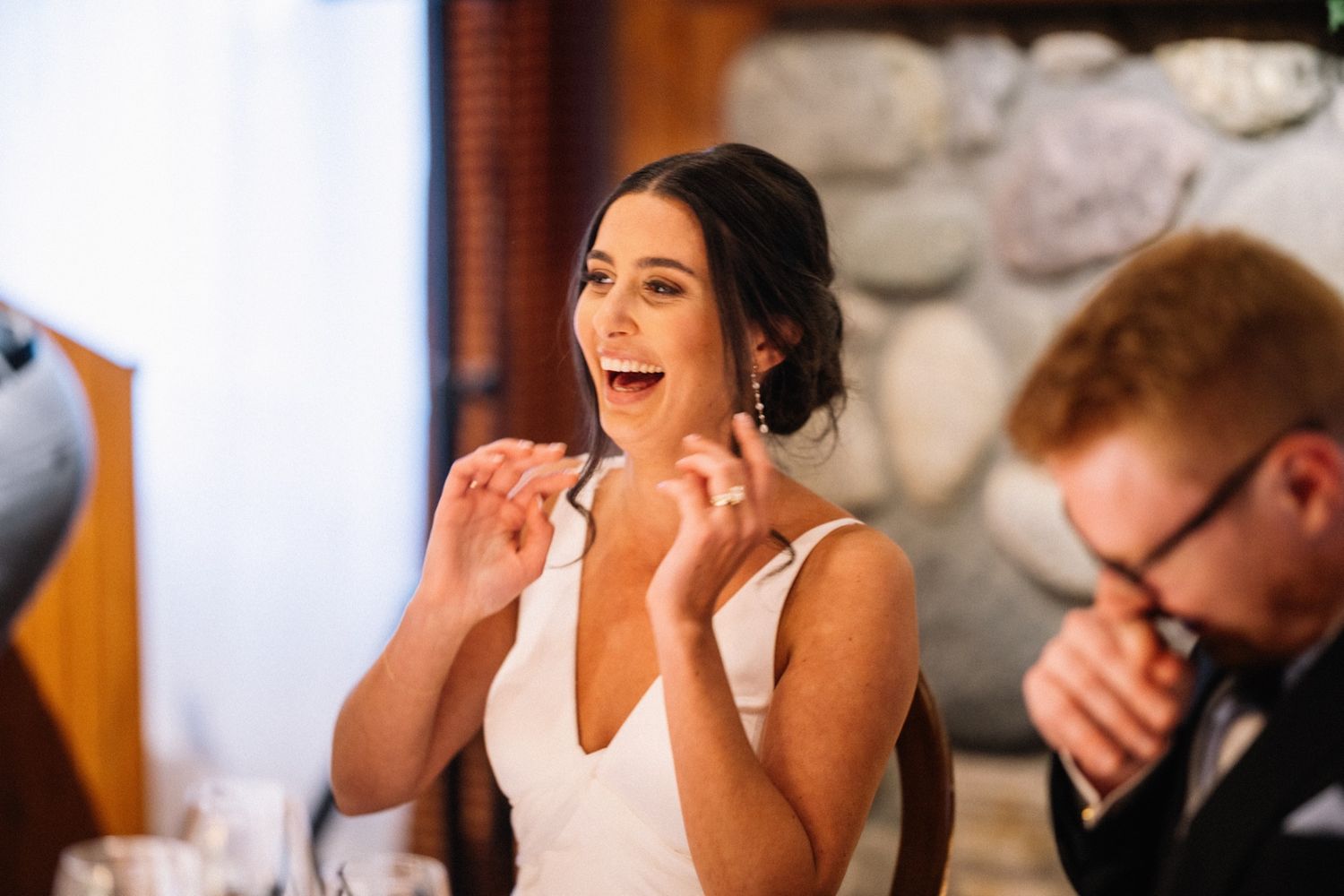 Bride laughing during the speeches at her Post Hotel wedding reception