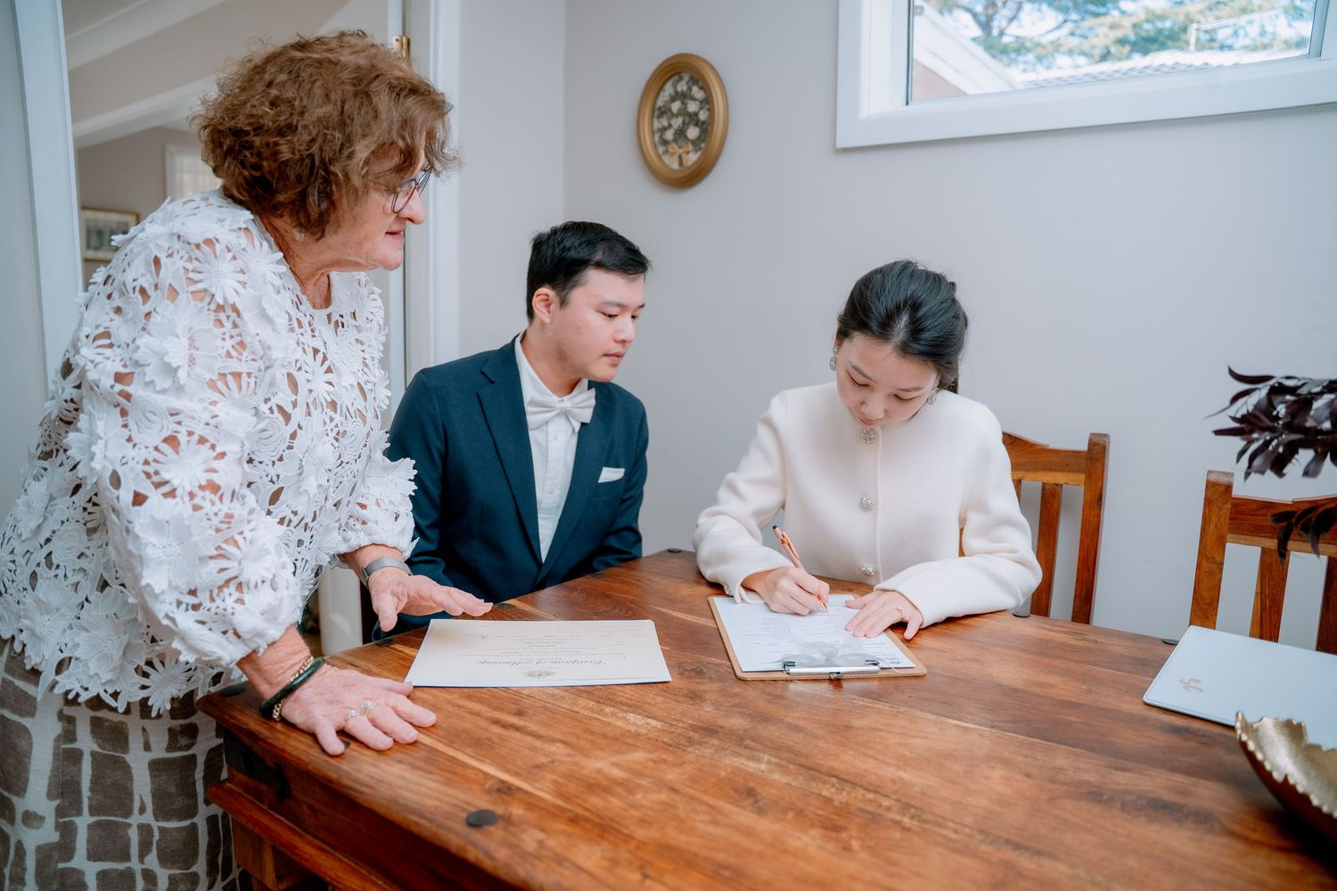 Witness signing the marriage documents at a wooden table - legal paperwork at an Australian elopement