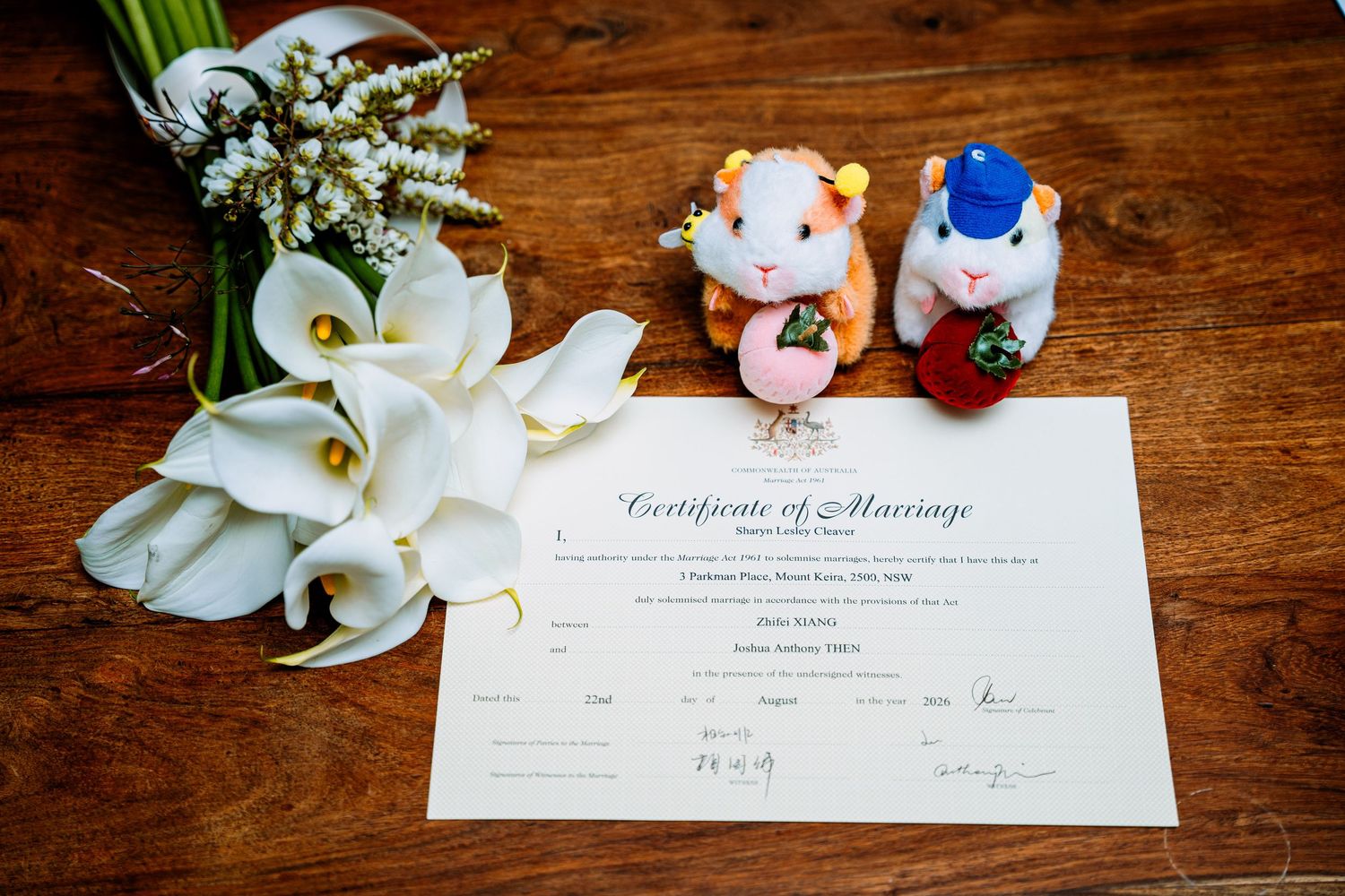 Marriage certificate with white calla lilies and tiny bride and groom figurines - elopement detail photography