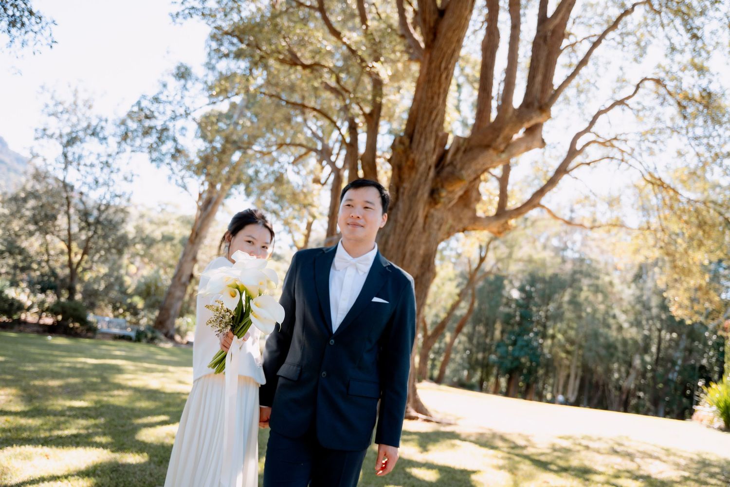 Bride and groom under tall gum trees in the sunshine - Australian bush-style elopement portraits