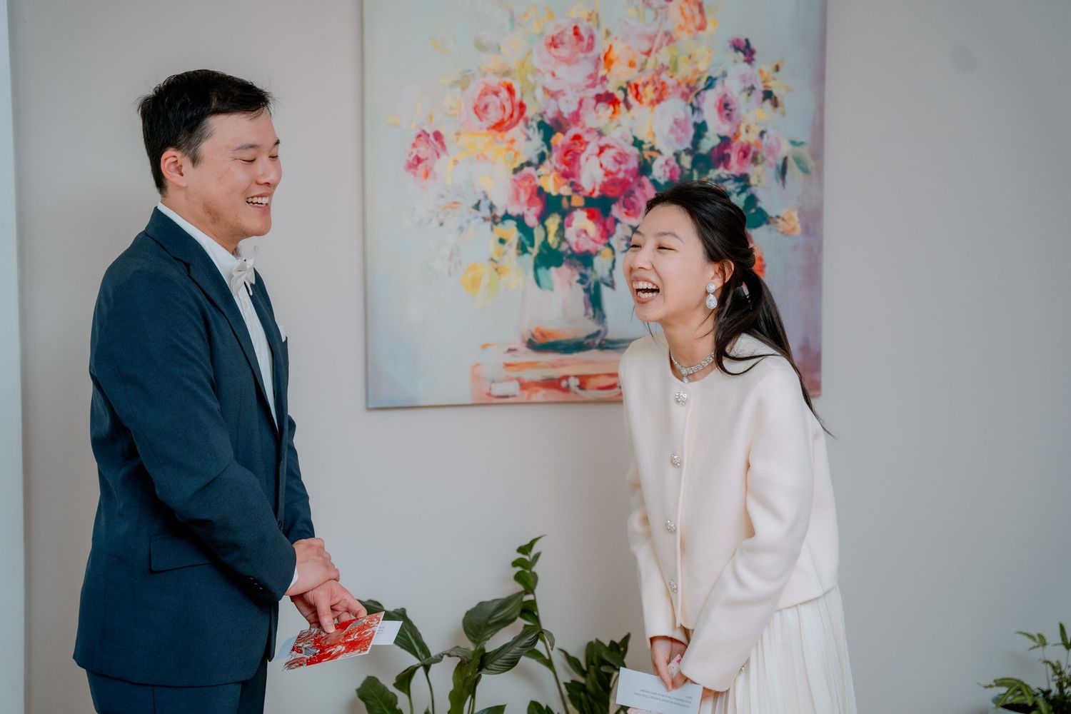 Laughing couple in front of a colourful floral painting - candid moment at an intimate Sydney elopement