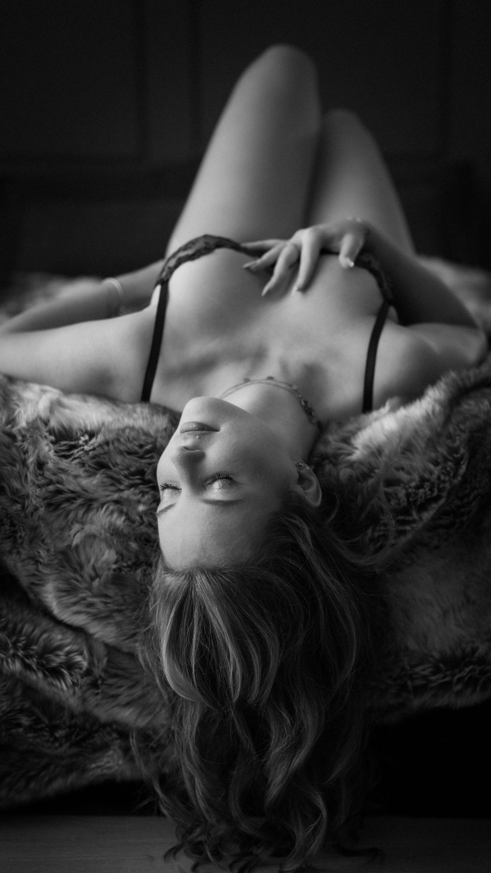 Stimmungsvolles Schwarz-Weiß-Boudoir-Porträt einer Frau in eleganter Lingerie.