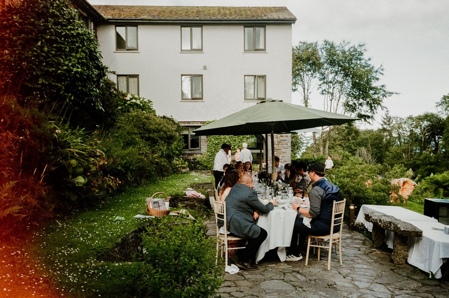 35mm film scan of Guests dining outdoors on the patio at hotel meudon wedding venue.