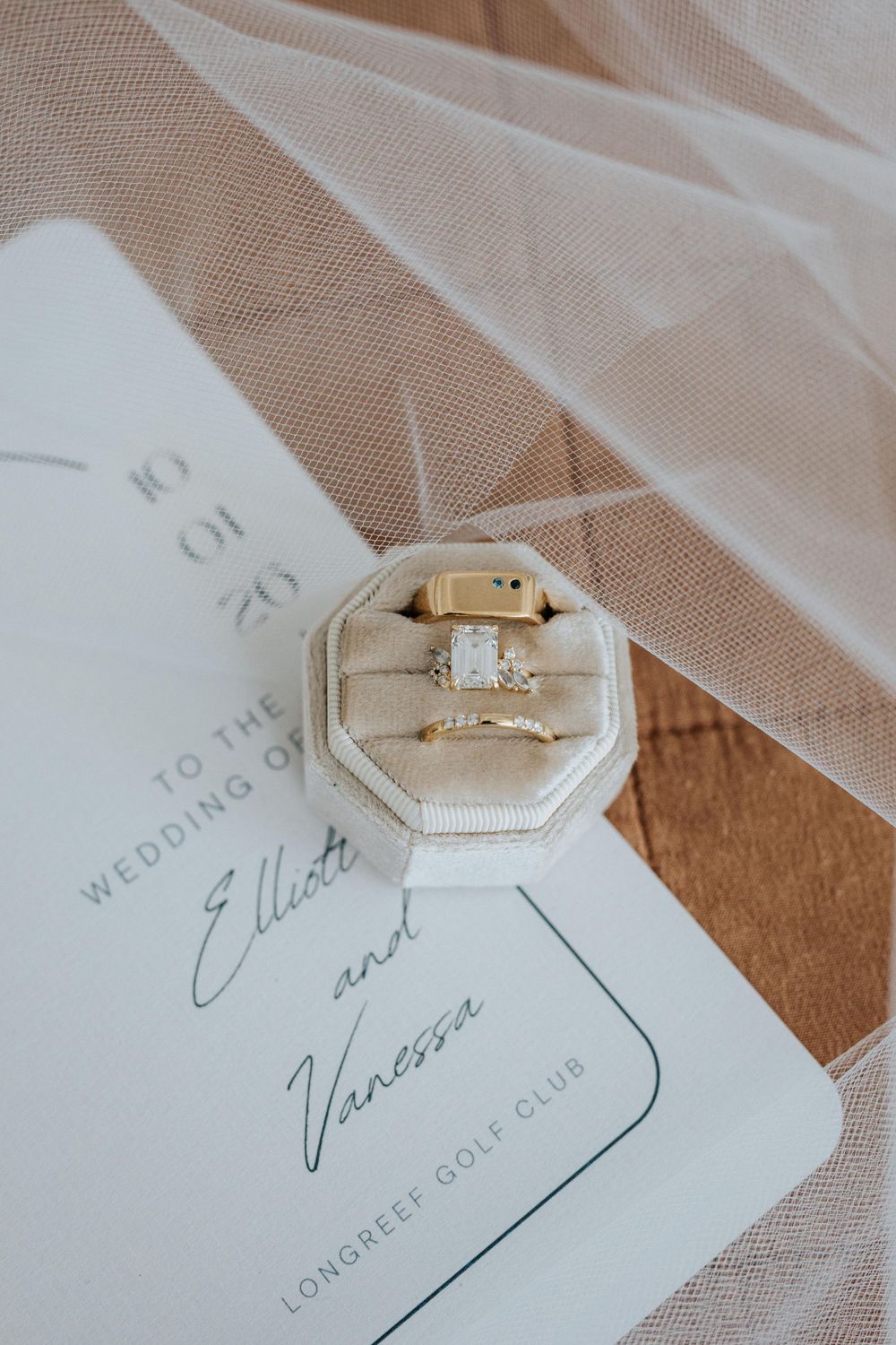 Gold engagement ring and wedding band in velvet box on wedding invitation for Elliott and Vanessa at Longreef Golf Club.