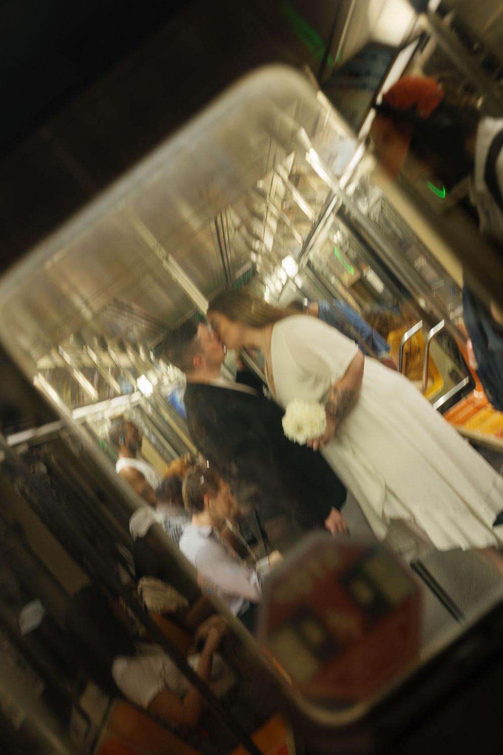 Blurry motion shot of people inside a busy restaurant kitchen with stainless steel equipment and warm lighting.