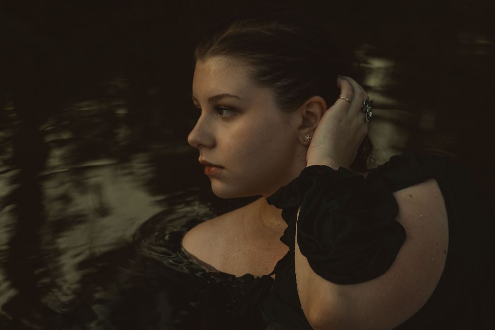 Dreamy senior photography in Spokane, Washington featuring portraits captured in the water with a cinematic, artistic feel.