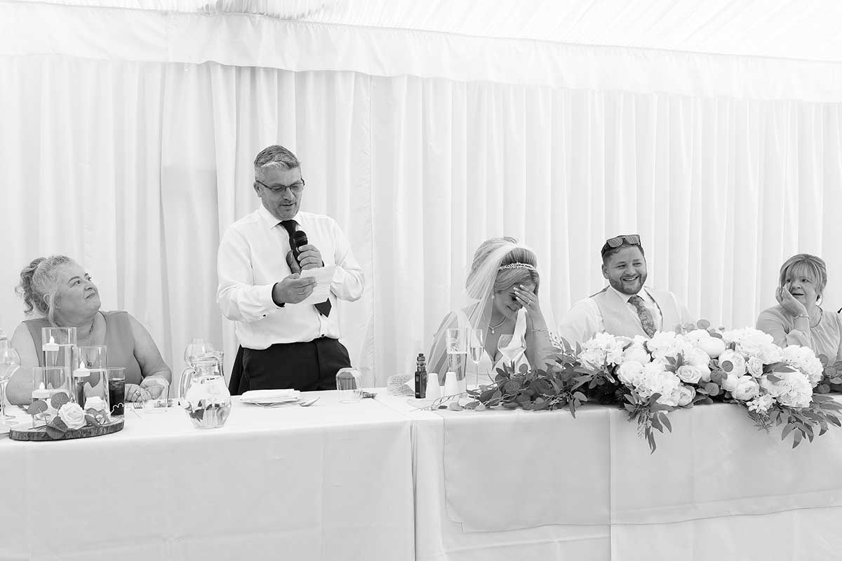 Father of the bride gives a speech at the wedding breakfast, much to the dismay of the bride at Dalston Hall