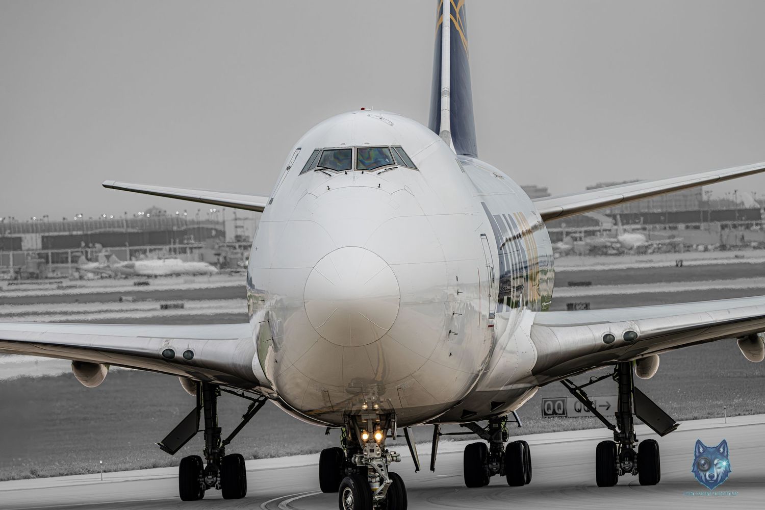 Large commercial Boeing 747 aircraft taxiing on snowy airport runway in overcast winter weather conditions.