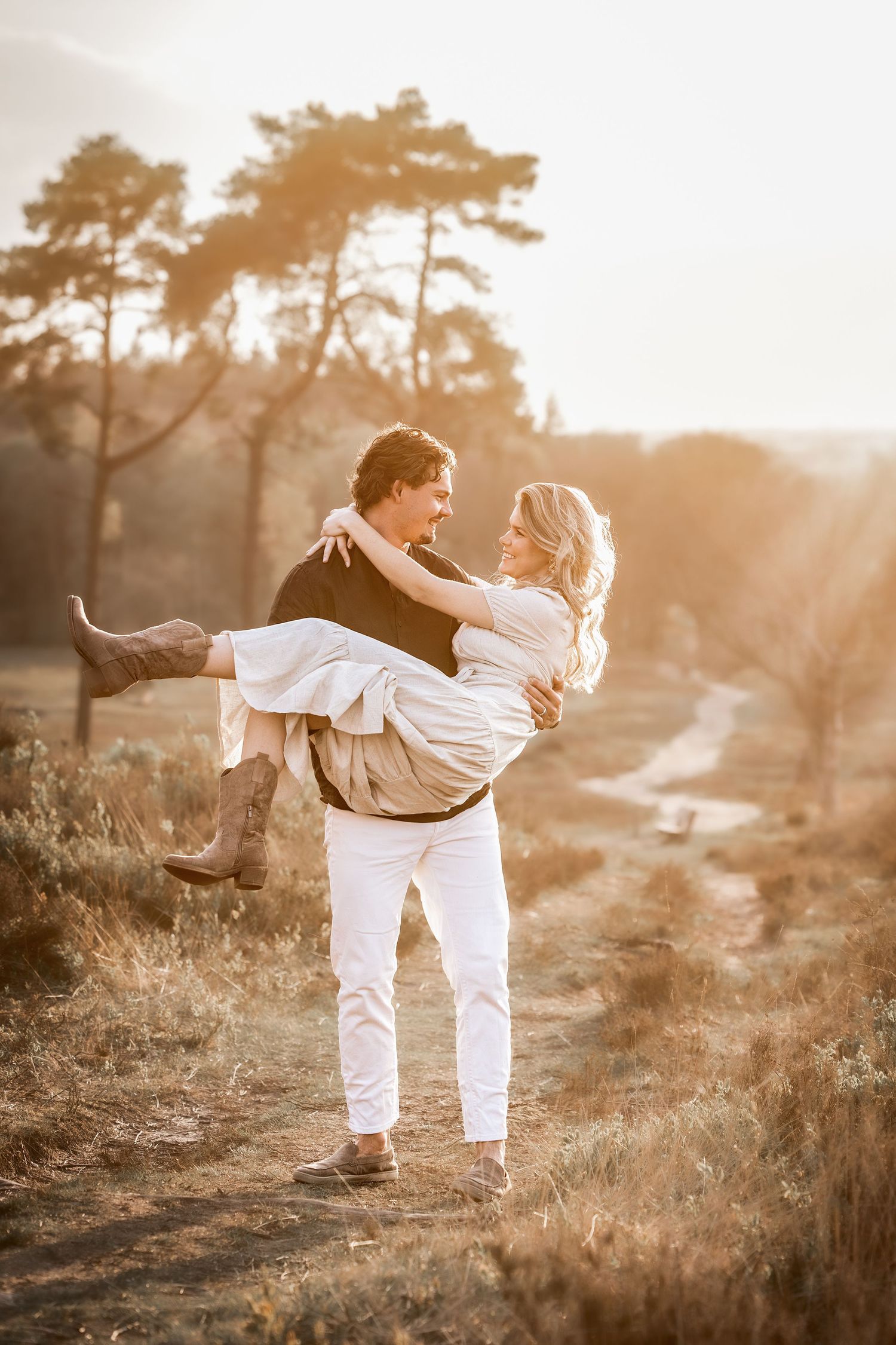 foto van een verliefd koppel op de Lemelerberg waarbij hij haar optilt