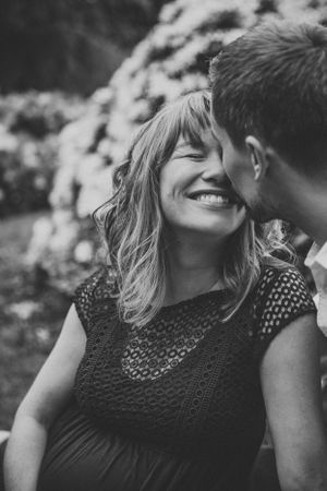 An intimate black and white portrait capturing a joyful moment between a couple outdoors.