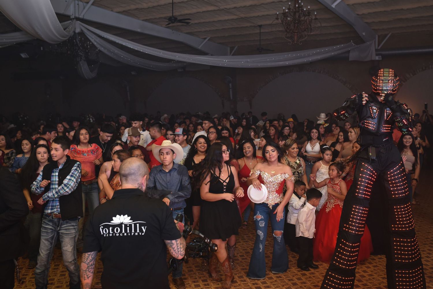 Large Quince guest line waiting outside venue highlighting open invite Quinceañera planning, RSVP tracking and venue capacity limits