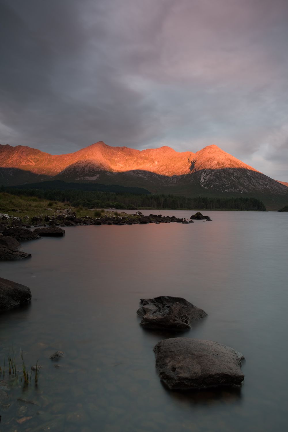 Tramonto sulle montagne dei Twelve Bens e sul lago in verticale