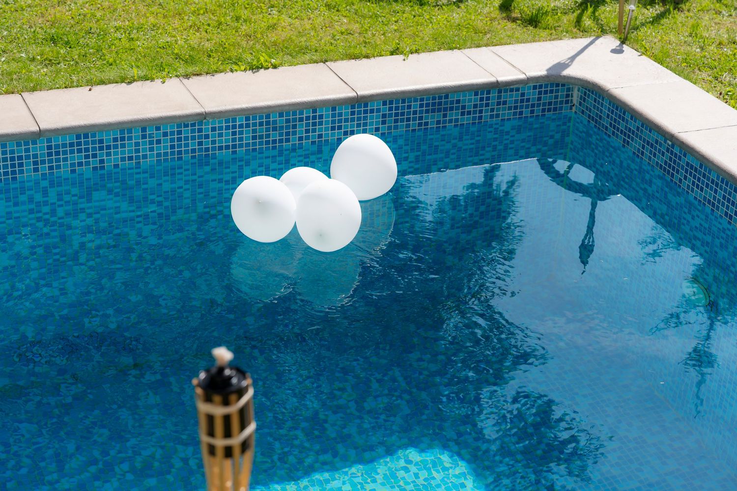 Black and white photo of bride and groom holding hands, showcasing wedding dress lace detail and groom suit.