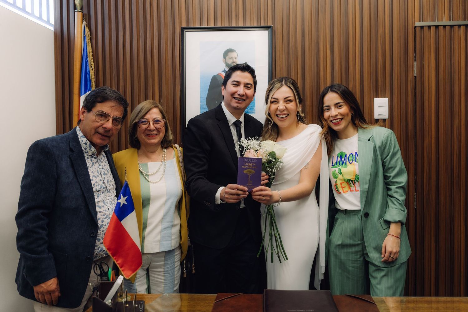 Bride and groom celebrating with four guests at Chilean civil wedding registry office.