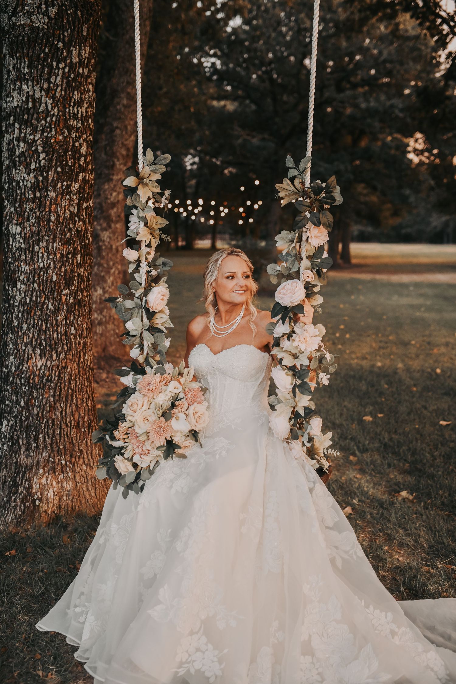 a close up of the bride a flower covered bridal swing at the white sparrow wedding venue