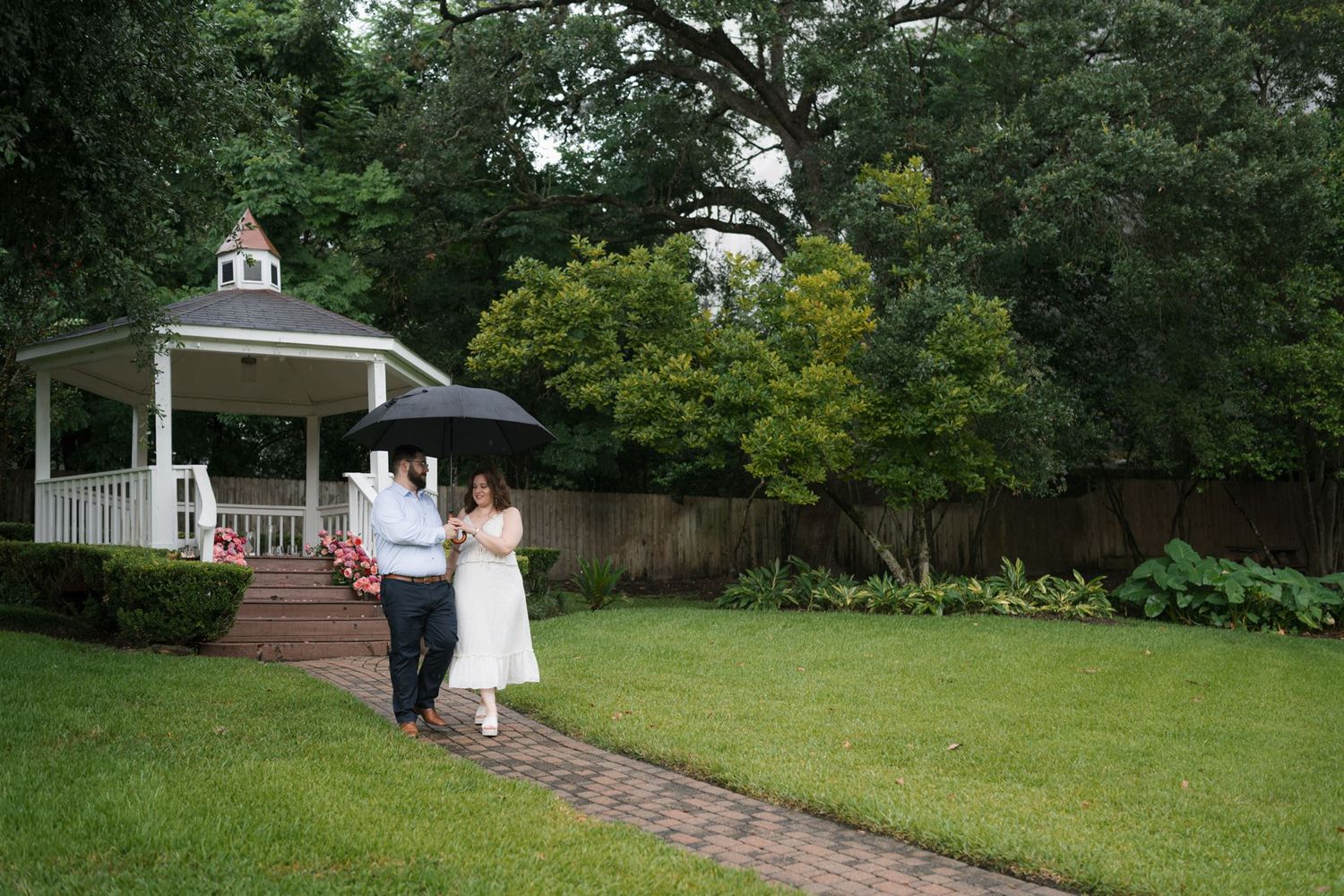 Newly engaged couple celebrating in the gardens at Brenner's on the Bayou