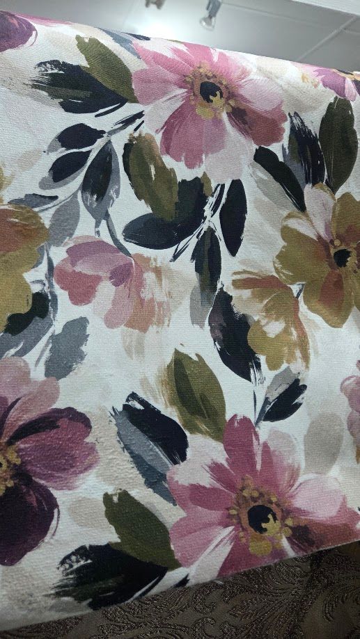 Watercolor floral fabric featuring pink, burgundy, and gold flowers with green and black leaves on a white background.