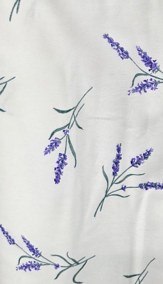 White fabric with scattered purple lavender sprigs and green stems pattern, perfect for elegant home decor.
