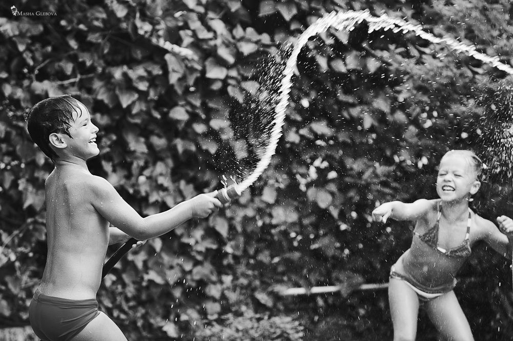 Black and white childhood photography capturing playful summer moments by Houston family photographer