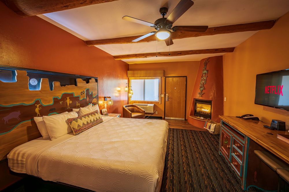 A hotel room at the luxury hotel, The Southwest Inn with a fireplace, bed & TV in Sedona, AZ.