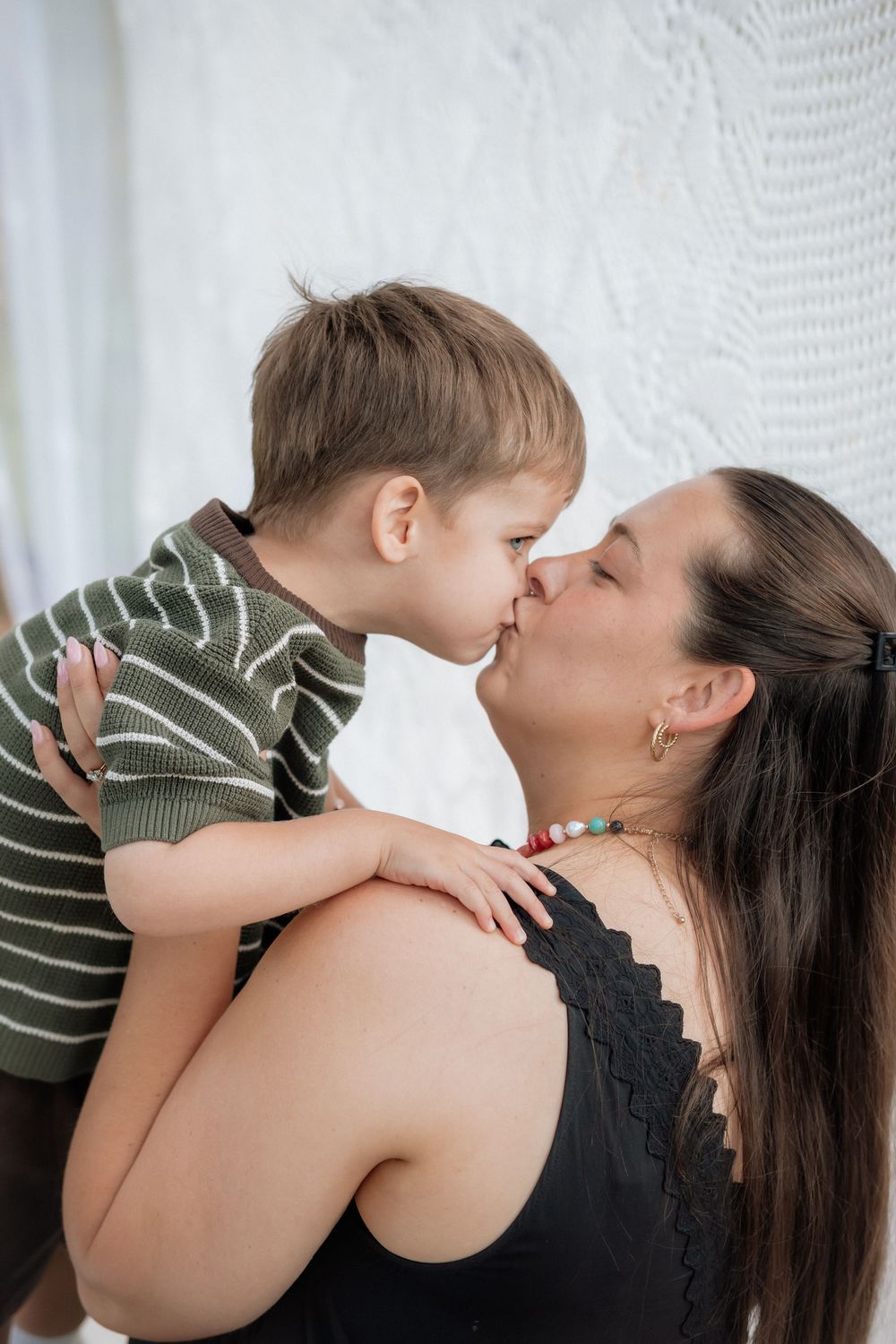 A sweet moment between parent and child showing affection and playfulness in a series of connected photos.