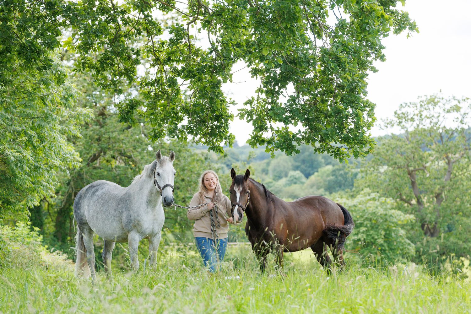 A horse and its rider enjoy an outdoor photoshoot session near rustic wooden fencing on a sunny day.