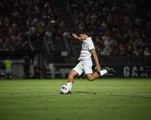 South Carolina soccer player strikes the ball under stadium lights.